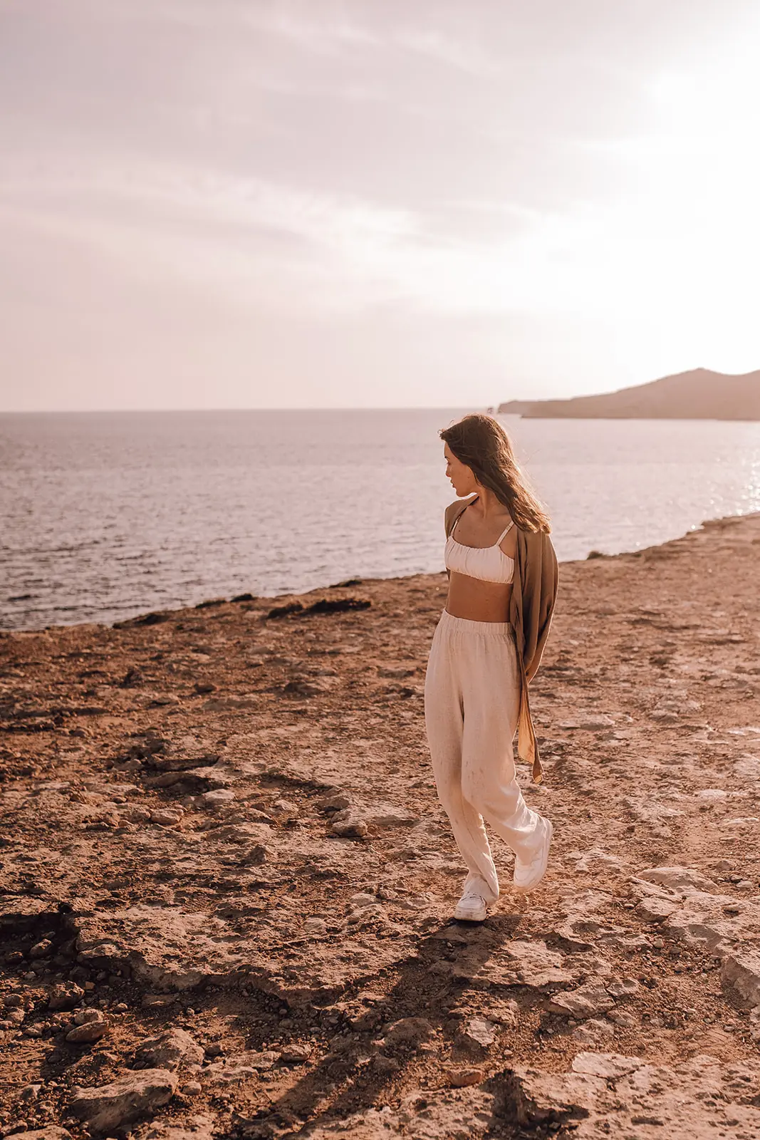 Een vrouw wandelt over de klif aan zee