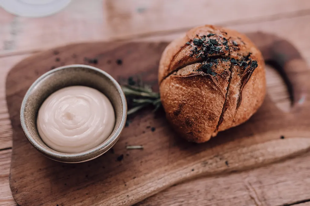 Vers brood met een romige dip op een houten plank
