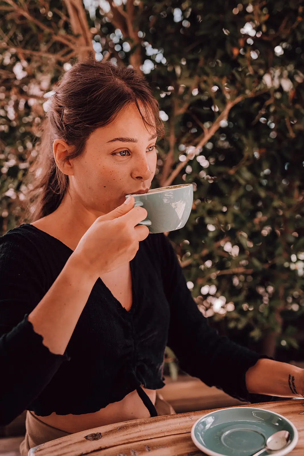 Een vrouw drinkt koffie in de ochtendzon