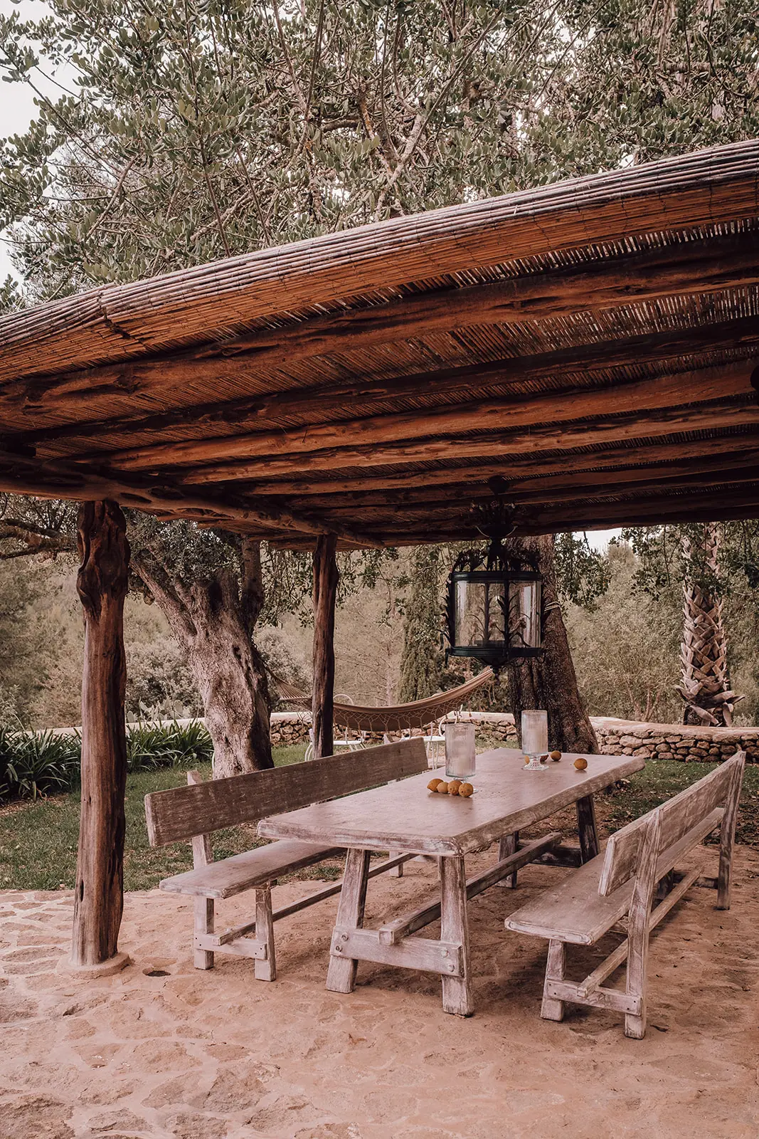 Houten banken en een tafel in de schaduw van de pergola