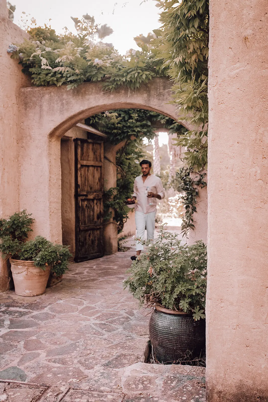 Rocco wandelt door de gewelfde poort van de finca